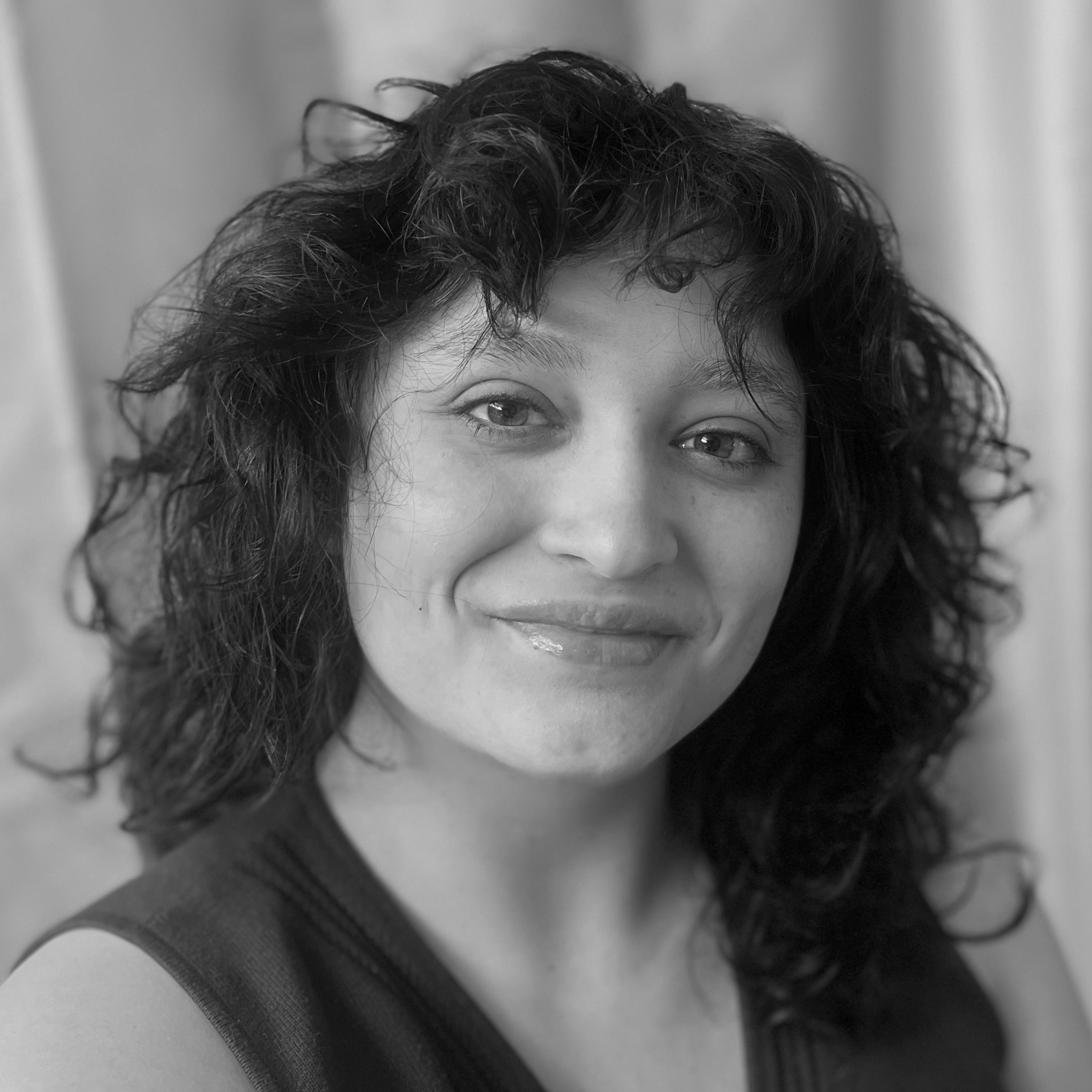 Black and white photo of Nina Kulikov smiling into the camera.