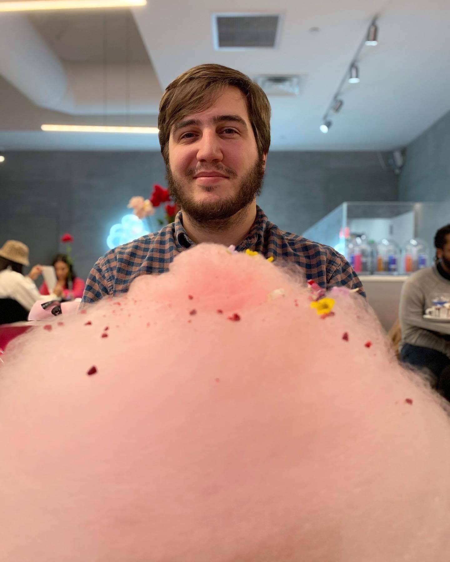Shane Davis posed behind a cloud of prink cotton candy