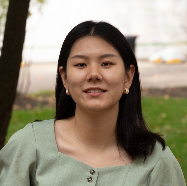 Headshot of Ziqi Wang outdoors, wearing a light green top and metallic earrings