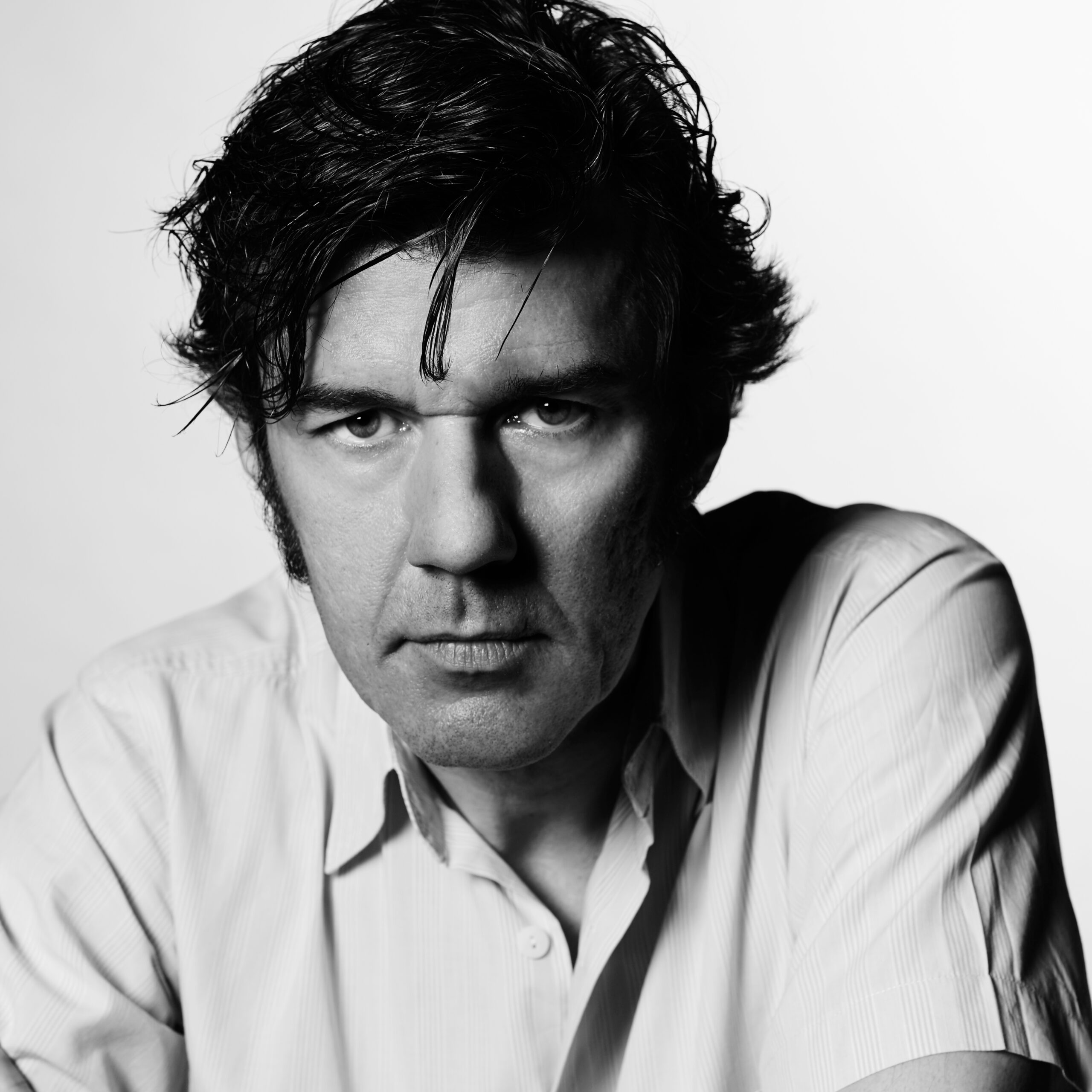Black and white photograph of Stefan Sagmeister looking intensely into the camera.