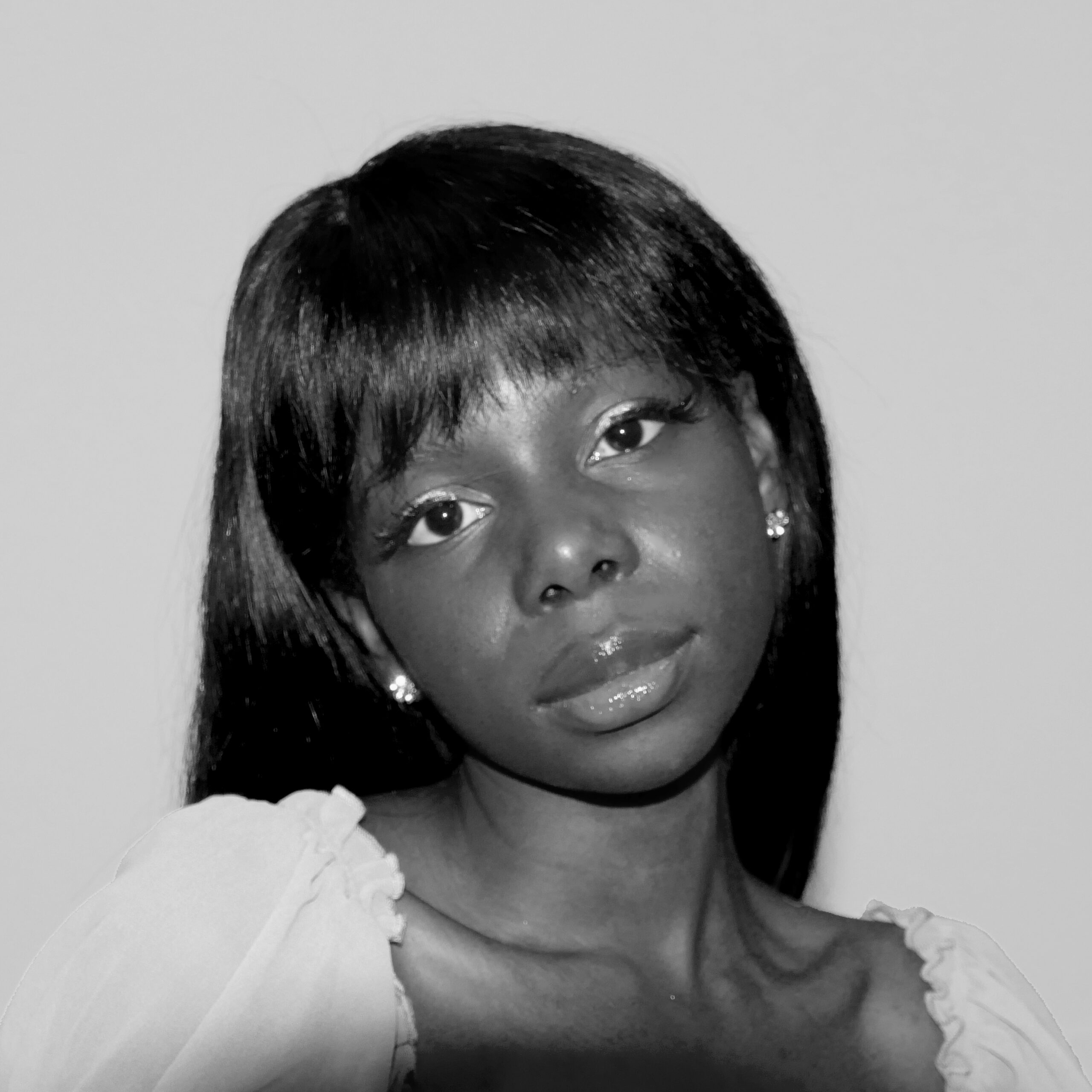 Black and white photo of Victoria Forbes looking into the camera. Her head it tilted slightly to the left.