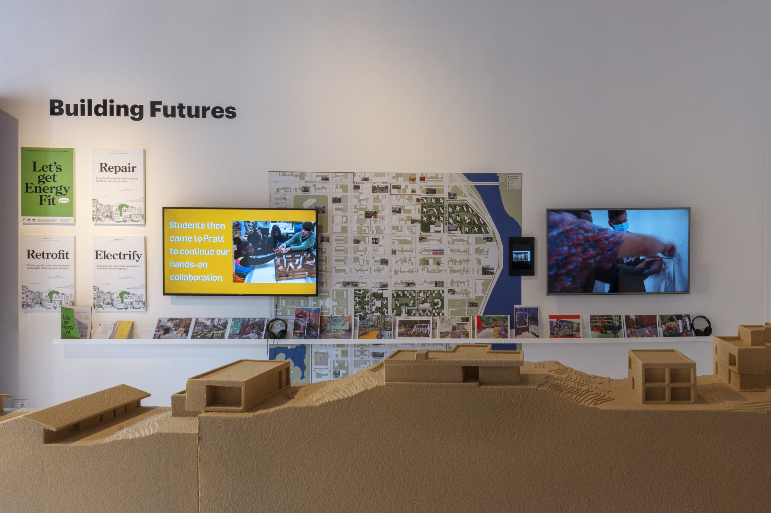 A room featuring display screens, posters, and architectural models.