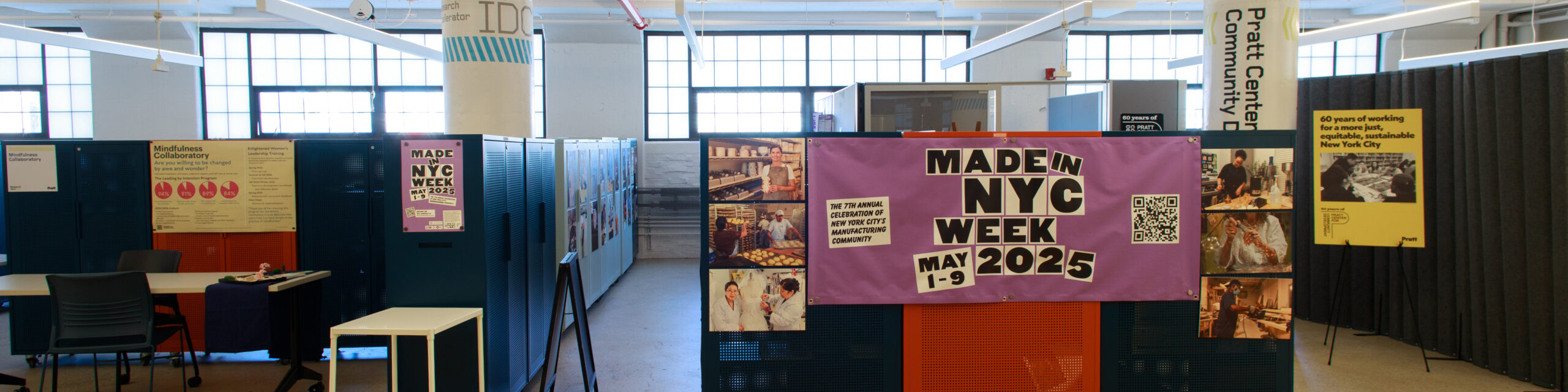 A banner designed for Made In NYC hangs on cabinets inside a workspace.