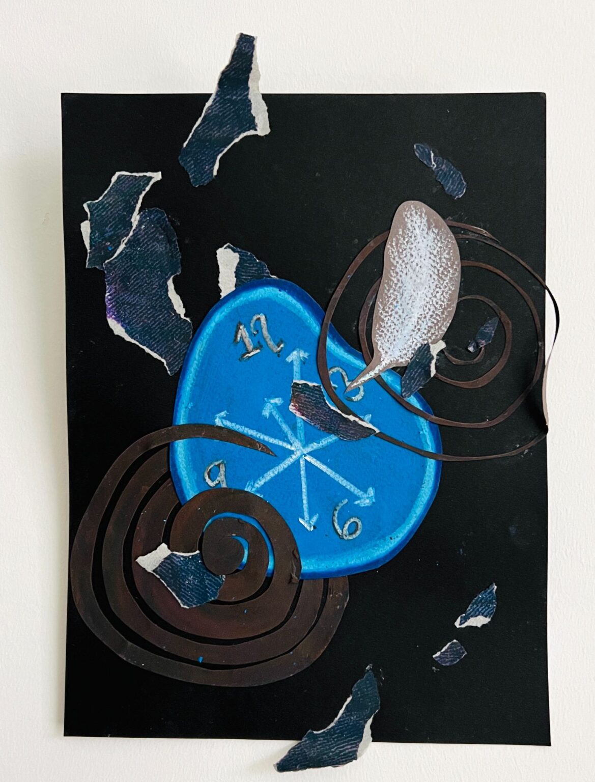 A mixed-media collage on a black background featuring a distorted blue clock face with white numbers and arrows. Surrounding it are swirling brown spiral shapes and torn fragments of textured blue paper, creating a fragmented and dynamic composition.