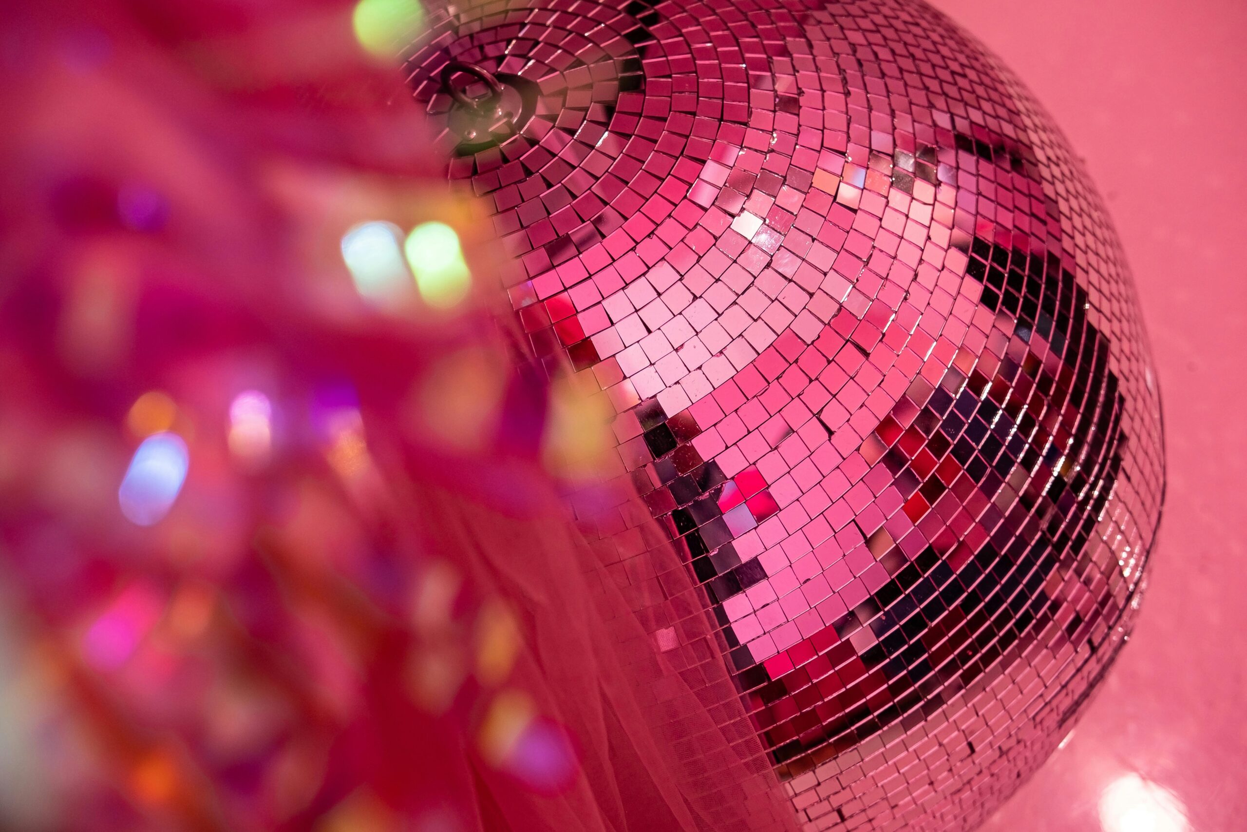 A magenta disco ball partially obscured by pink tulle
