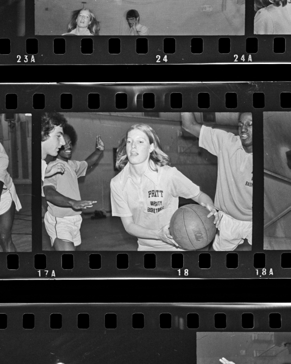 Cyndi Meserve runs down the court with a basketball, surrounded by three other players.