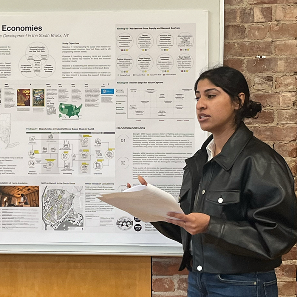 Student standing and talking in front of a research poster.