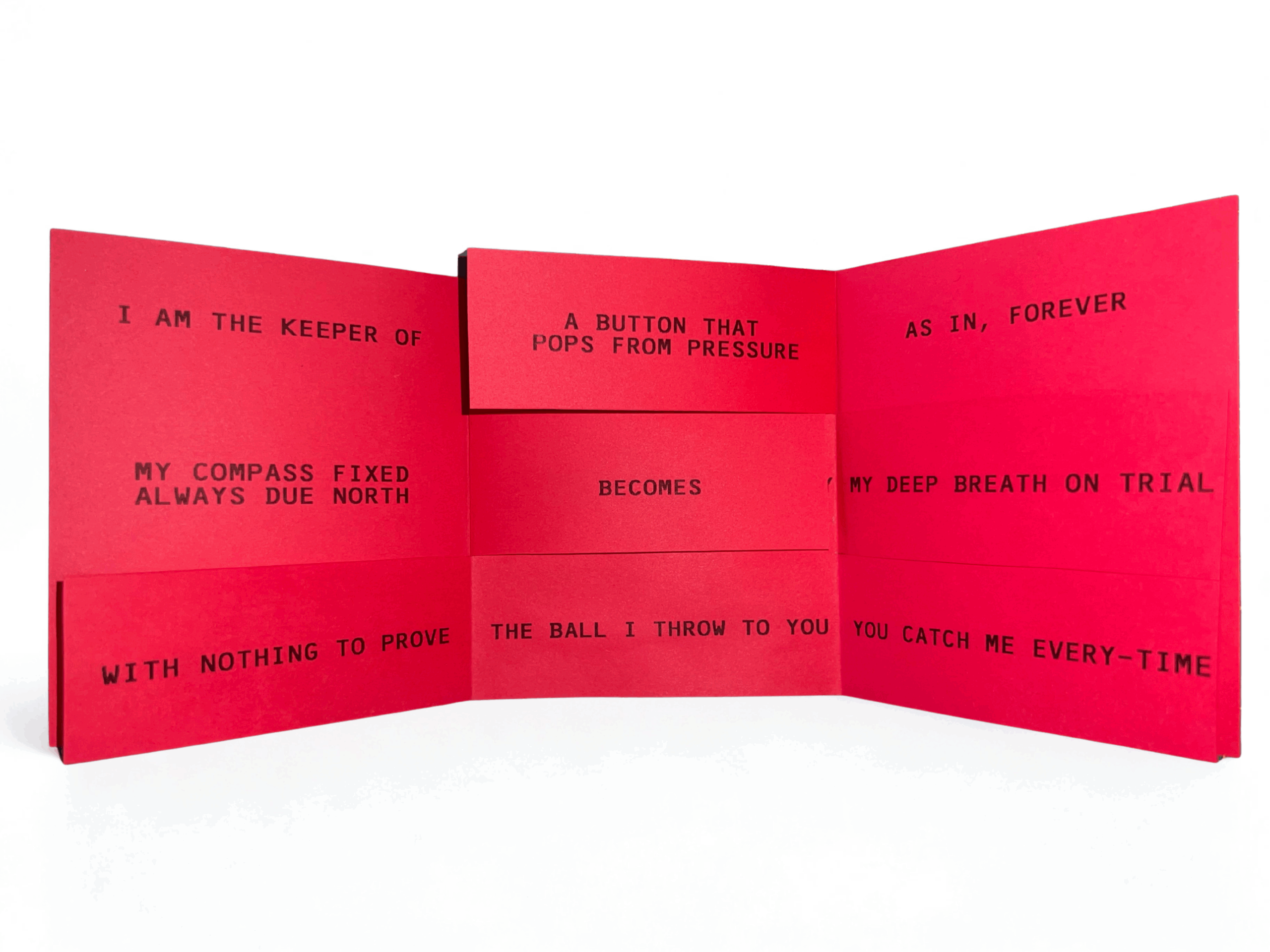 Red accordion-fold book fully extended on a white surface, showing black uppercase poetic text across panels including “A BUTTON THAT POPS FROM PRESSURE,” “BECOMES,” “THE BALL I THROW TO YOU,” and “YOU CATCH ME EVERY-TIME,” with visible creases and layered folds.