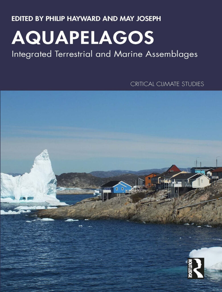 The front cover of the book “Aquapelagos: Integrated Terrestrial and Marine Assemblages” includes a photo of an iceberg beside small homes but into a rocky coastline. The back cover with author information is also displayed.