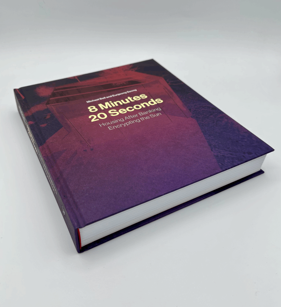  A printed copy of “8 Minutes 20 Seconds: Housing After Banking, Encrypting the Sun” sits on a white background.