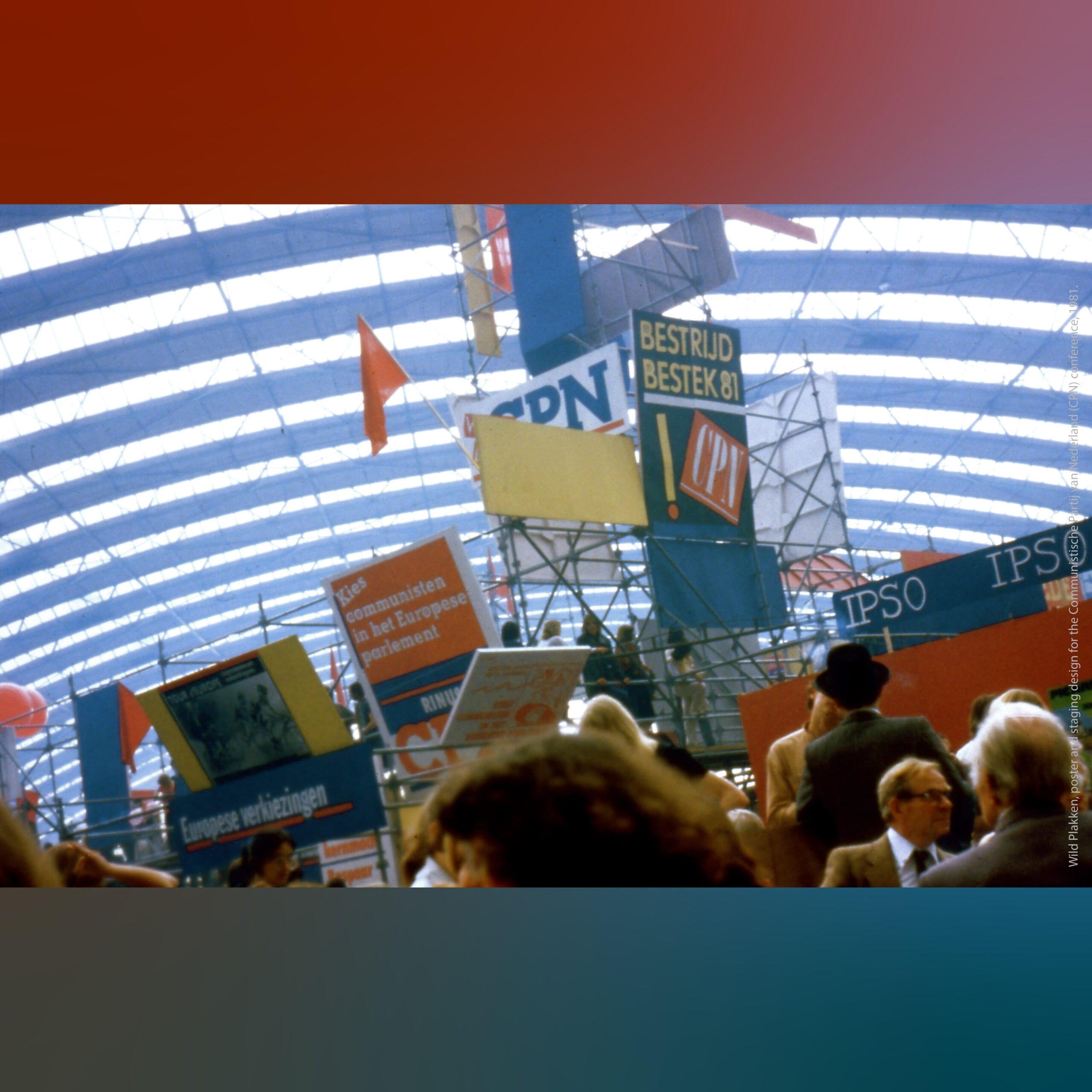 Crowded indoor hall with a high arched glass roof and scaffolding covered in colorful signs and posters, with people gathered below and banners visible throughout the space.