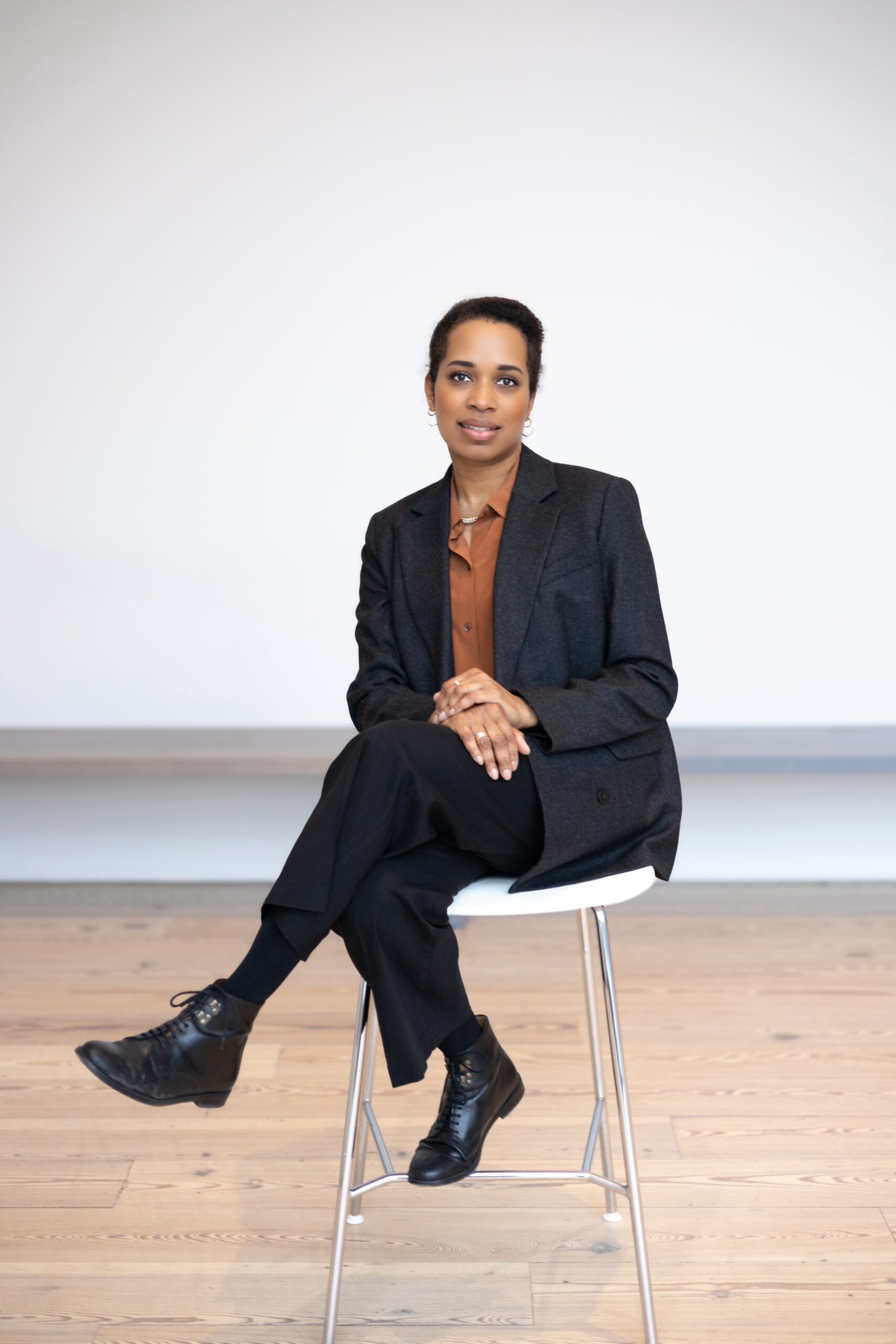 Alumna Vonetta DeVonish sits on a chair facing the camera with her legs crossed and hands in her lap against a white backdrop.