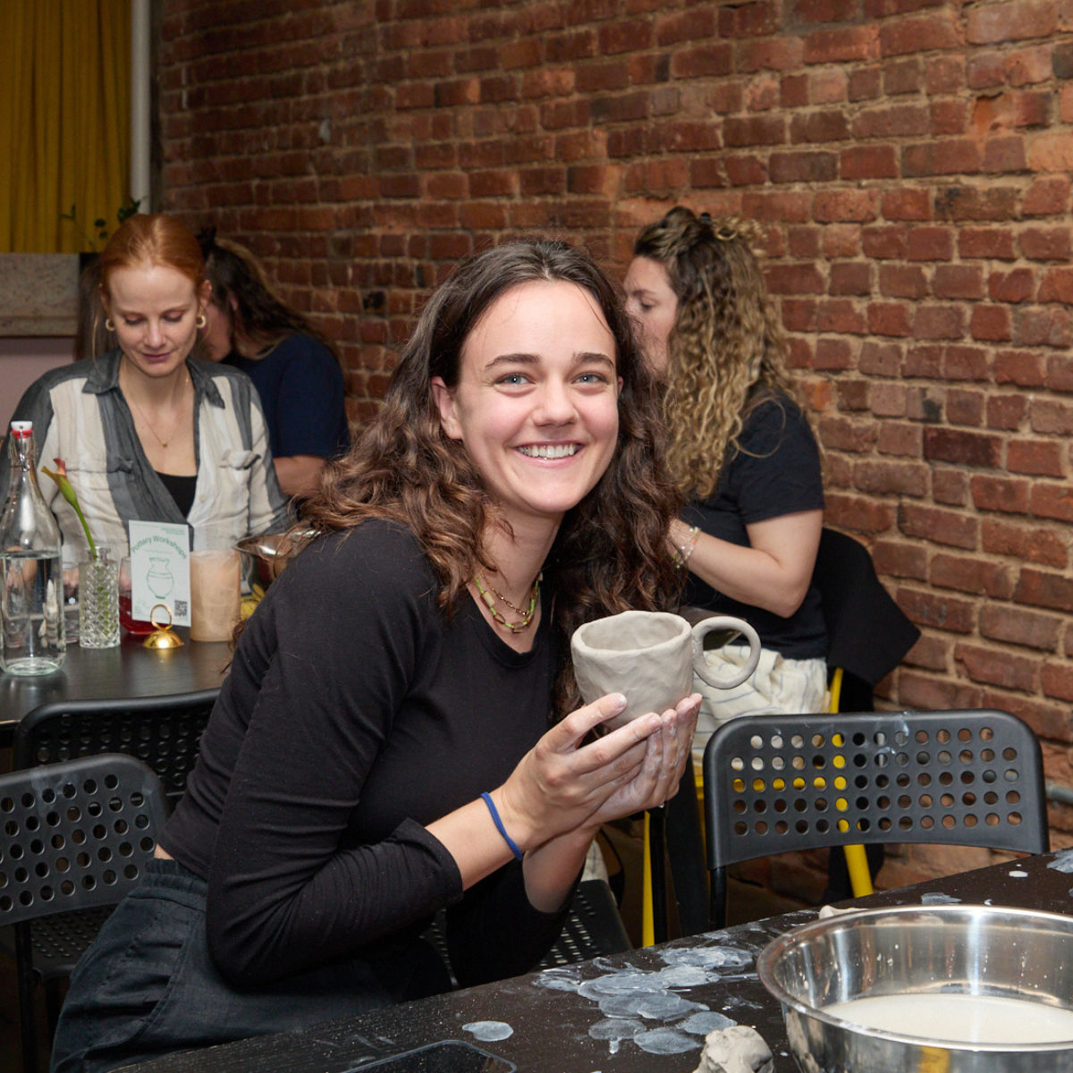 Made in NYC member holding clay coffee cup during demonstration