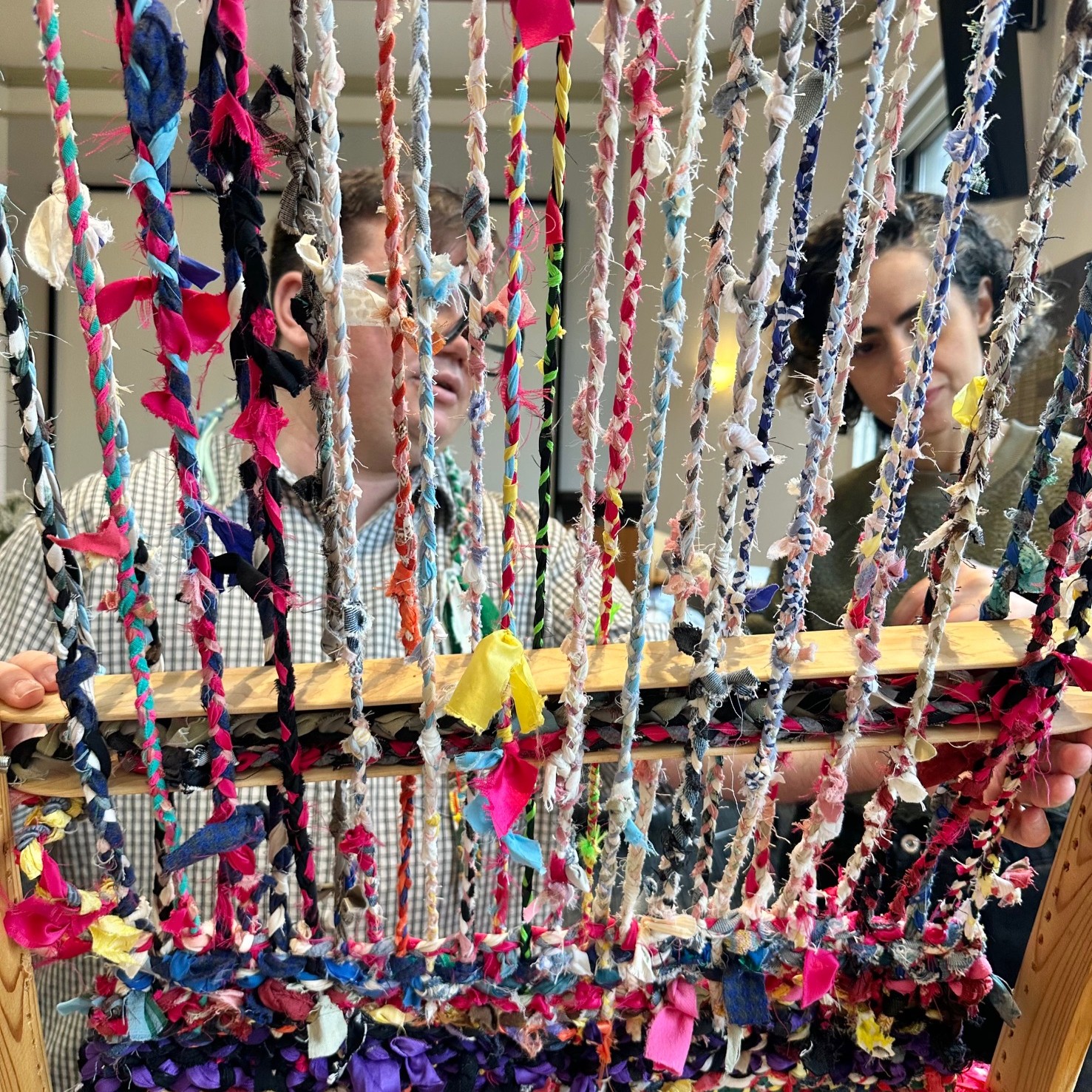 Artist weaving braided fabric