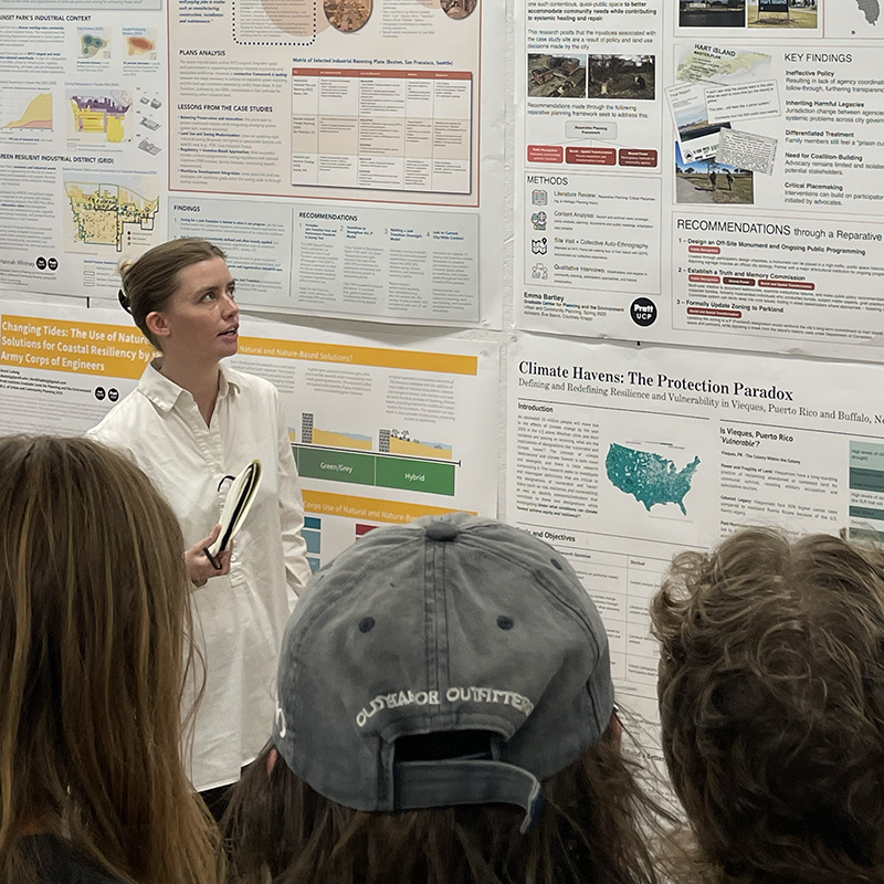 Student presenting her independent research as students, faculty, and alumni observe.