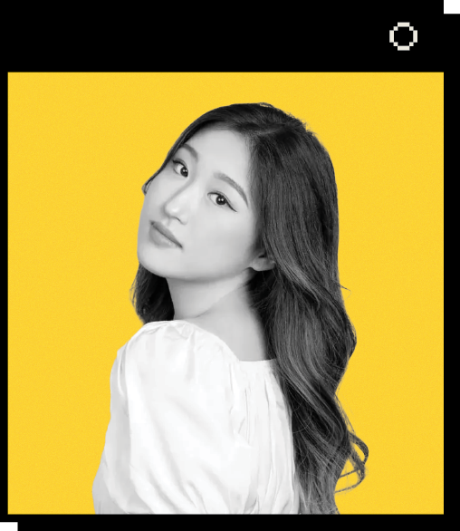 Headshot of Yvette Yoon against a yellow background. Yvette has long, wavy hair and is looking over her shoulder. She is wearing a white, puffy-sleeved blouse.