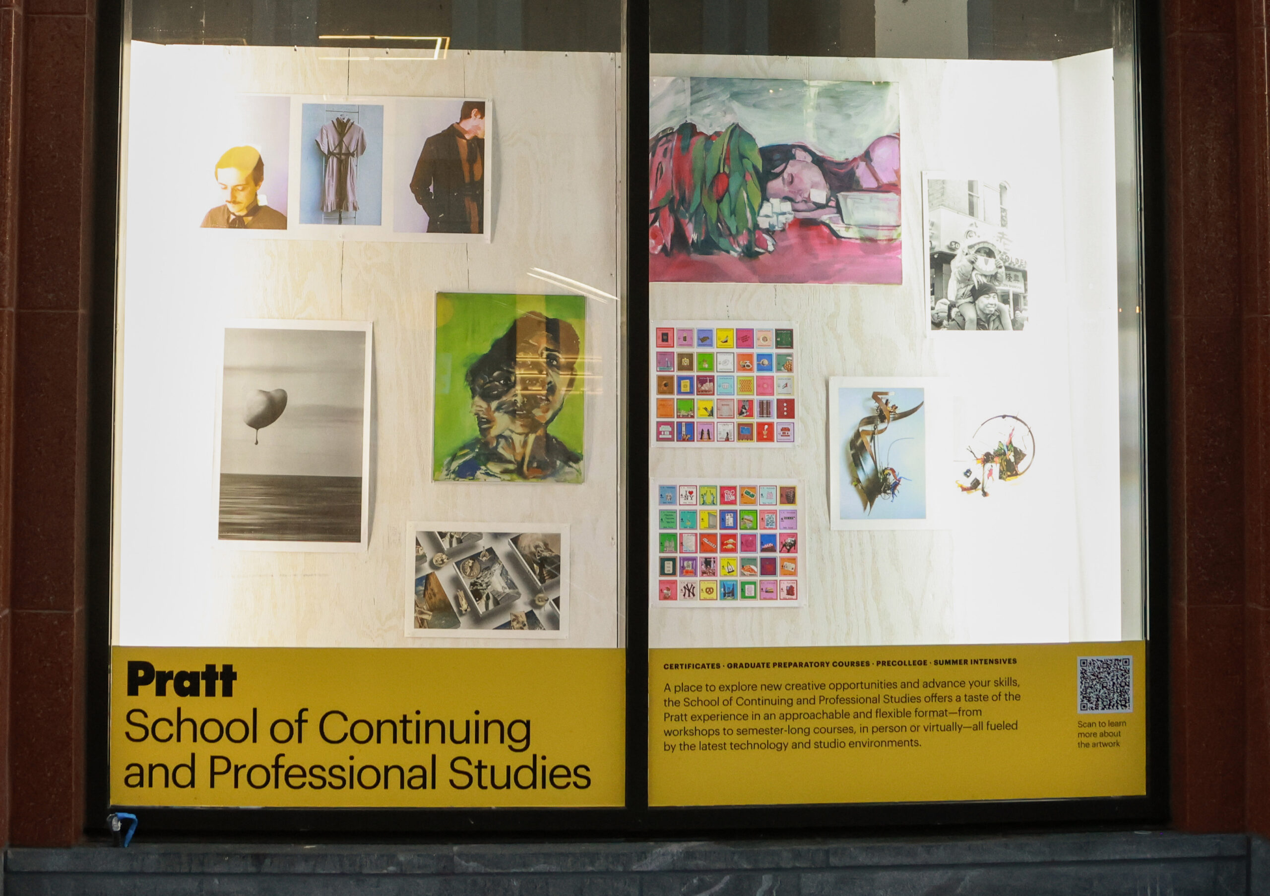 A window display features artwork from the Pratt School of Art. On the left, a colorful painting of a muscular figure, with fragmented edges, is contrasted by a surreal background. On the right, various photographs exhibit diverse subjects, including landscapes and posed models. A sculptural piece, resembling a boot, prominently sits at the bottom. Below, informative text highlights the school's mission and offerings.