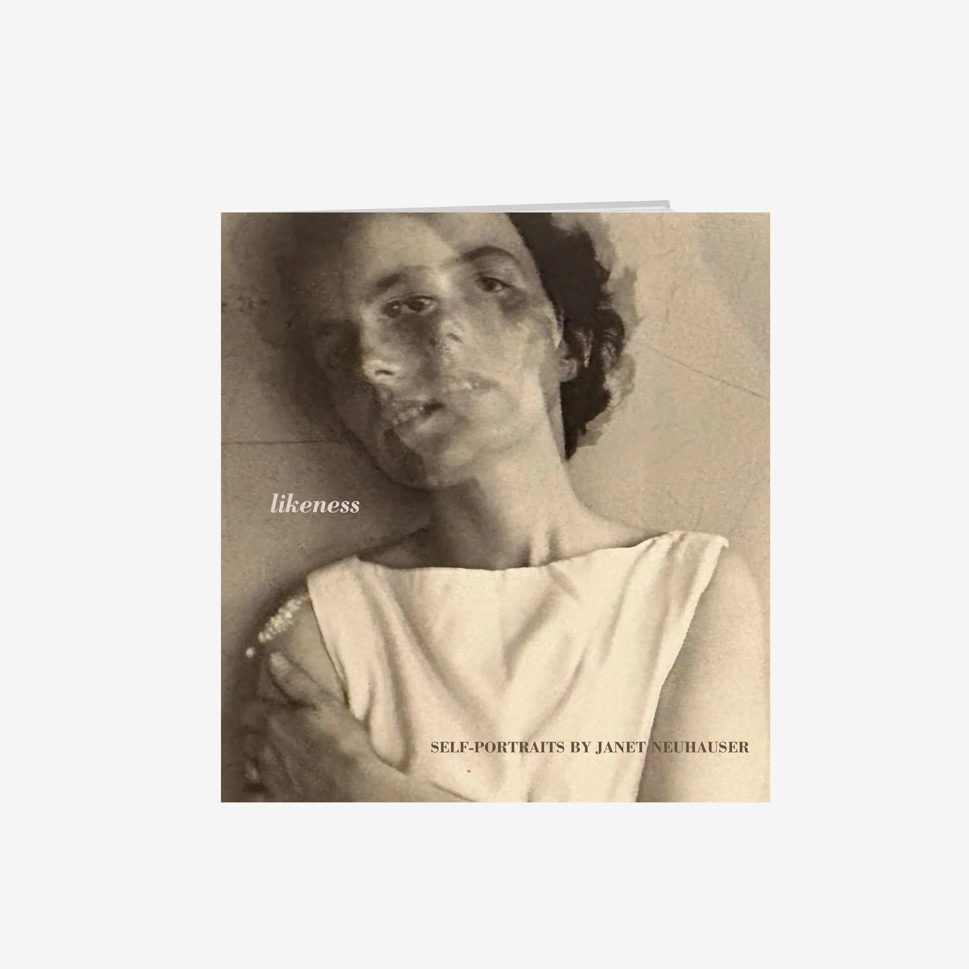 Book cover of Likeness: Self-Portraits by Janet Neuhauser. The cover features a double-exposed portrait of Neuhauser wearing a white tunic and staring at the camera, with one hand wrapped around her torso and touching her shoulder.