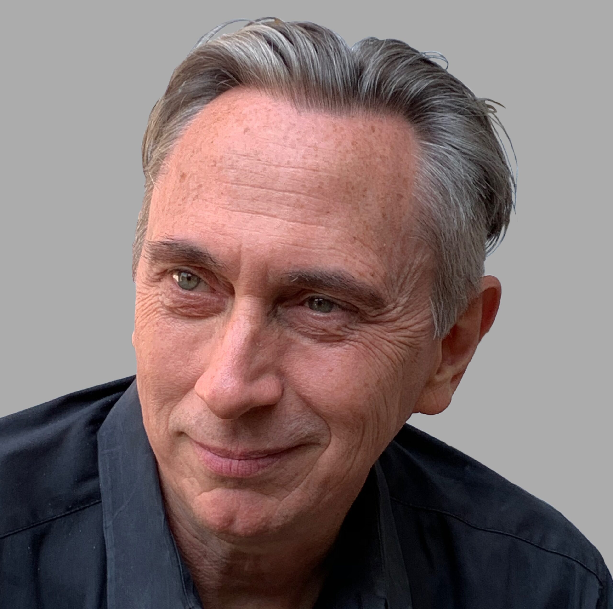 Man with short hair and dark shirt looks off camera.