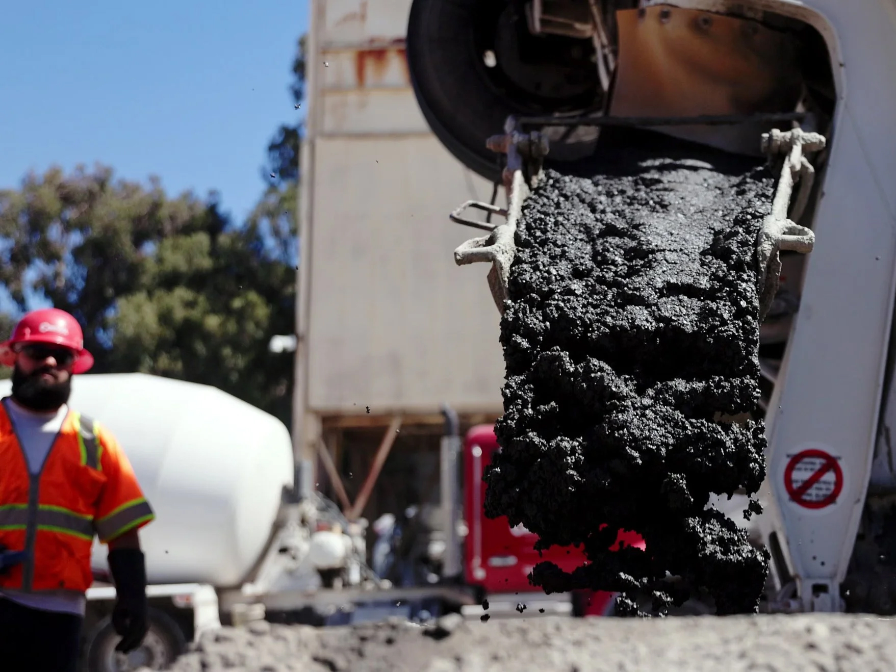 Biochar is being poured from a mixer onto a construction site.