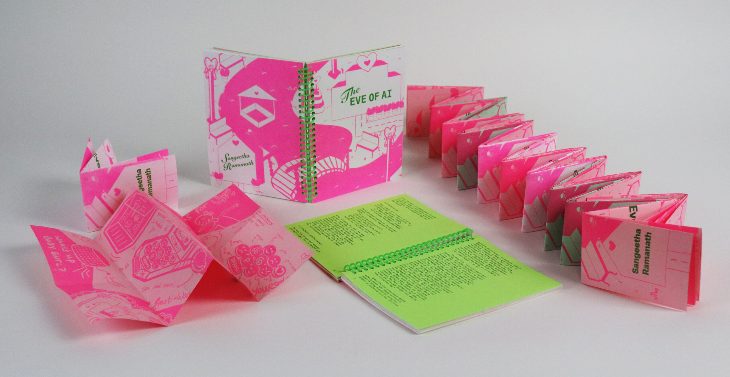A collection of colorful books displayed on a white surface. The main book, titled "The Eve of AI," is centrally positioned, featuring a spiral binding and bright pink cover with illustrations. Surrounding it are smaller pink and green folded books with various graphics. To the left, a green booklet is open, showcasing text on its pages. The overall aesthetic is vibrant and playful.
