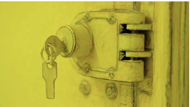 A close-up of a yellow-painted door lock with a key inserted into the keyhole. The surrounding area is also yellow, creating a monochromatic effect. The lock has a bolt mechanism visible beside it.