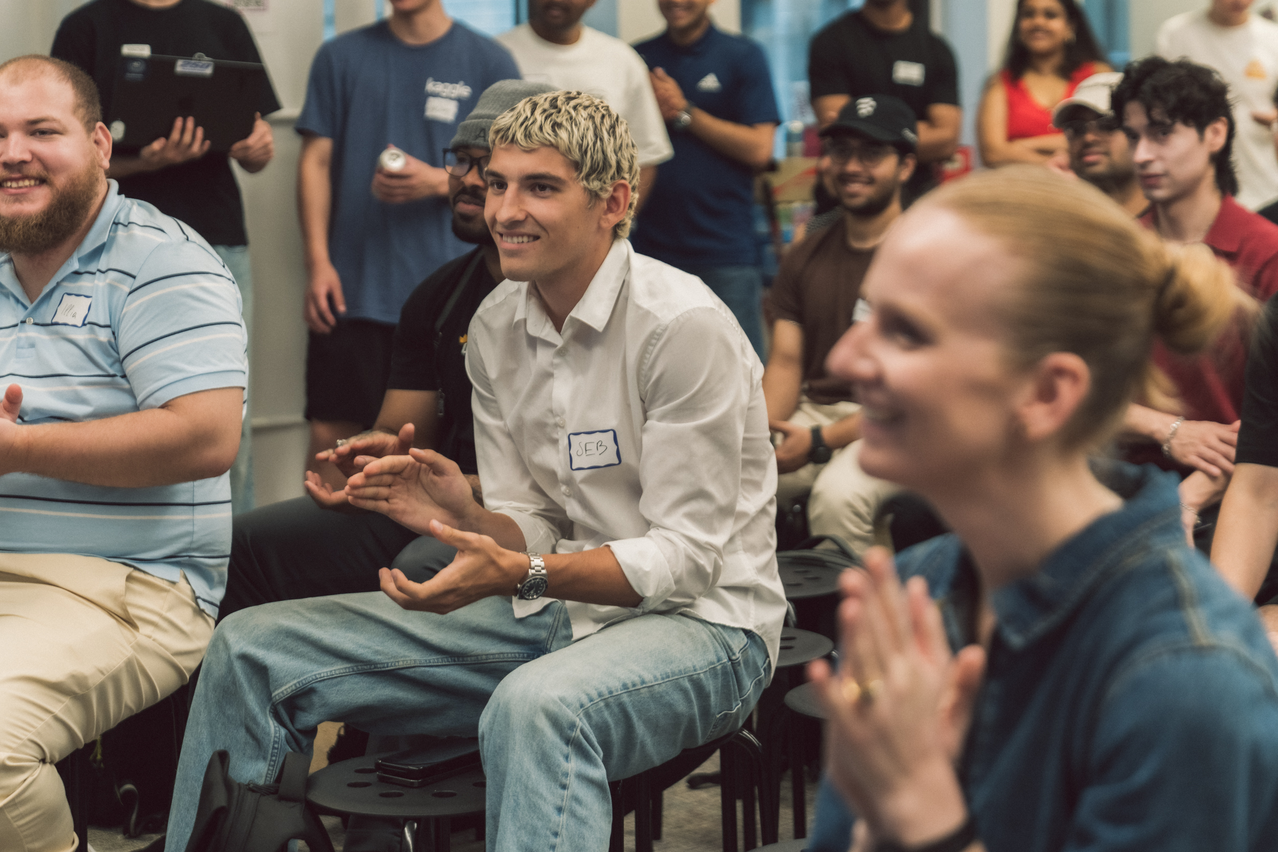 Alum Sebastian Roda seated in a crowd, clapping his hands