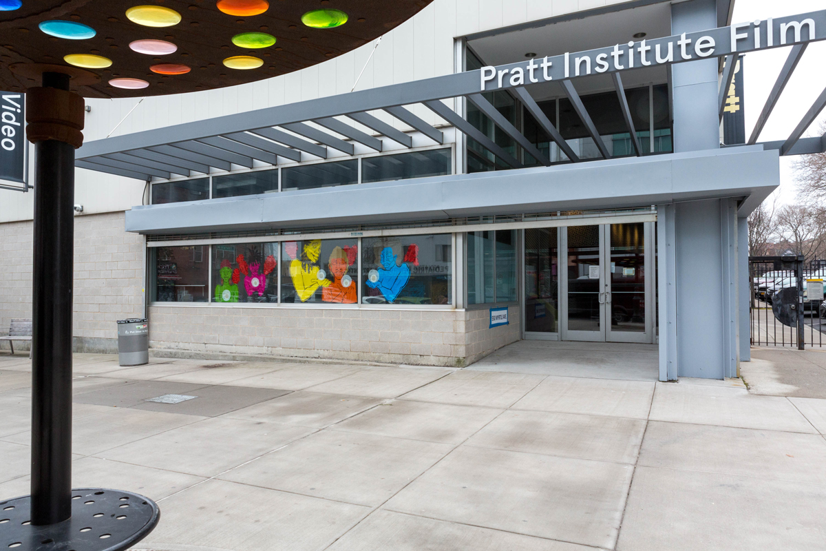 A photo of the exterior of the Pratt Film/Video Building that shows Devin Alexander's work installed in the windows.