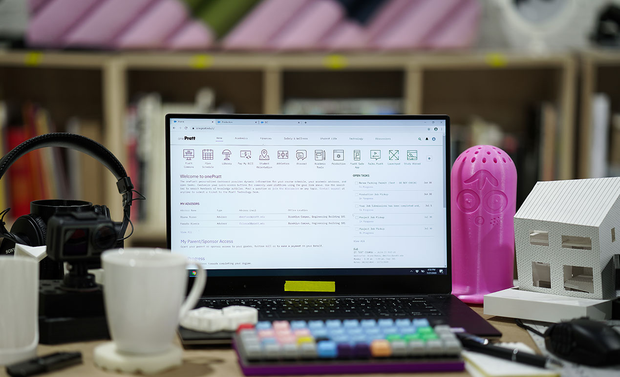 A photo of a laptop on a desk open to the onePratt platform.