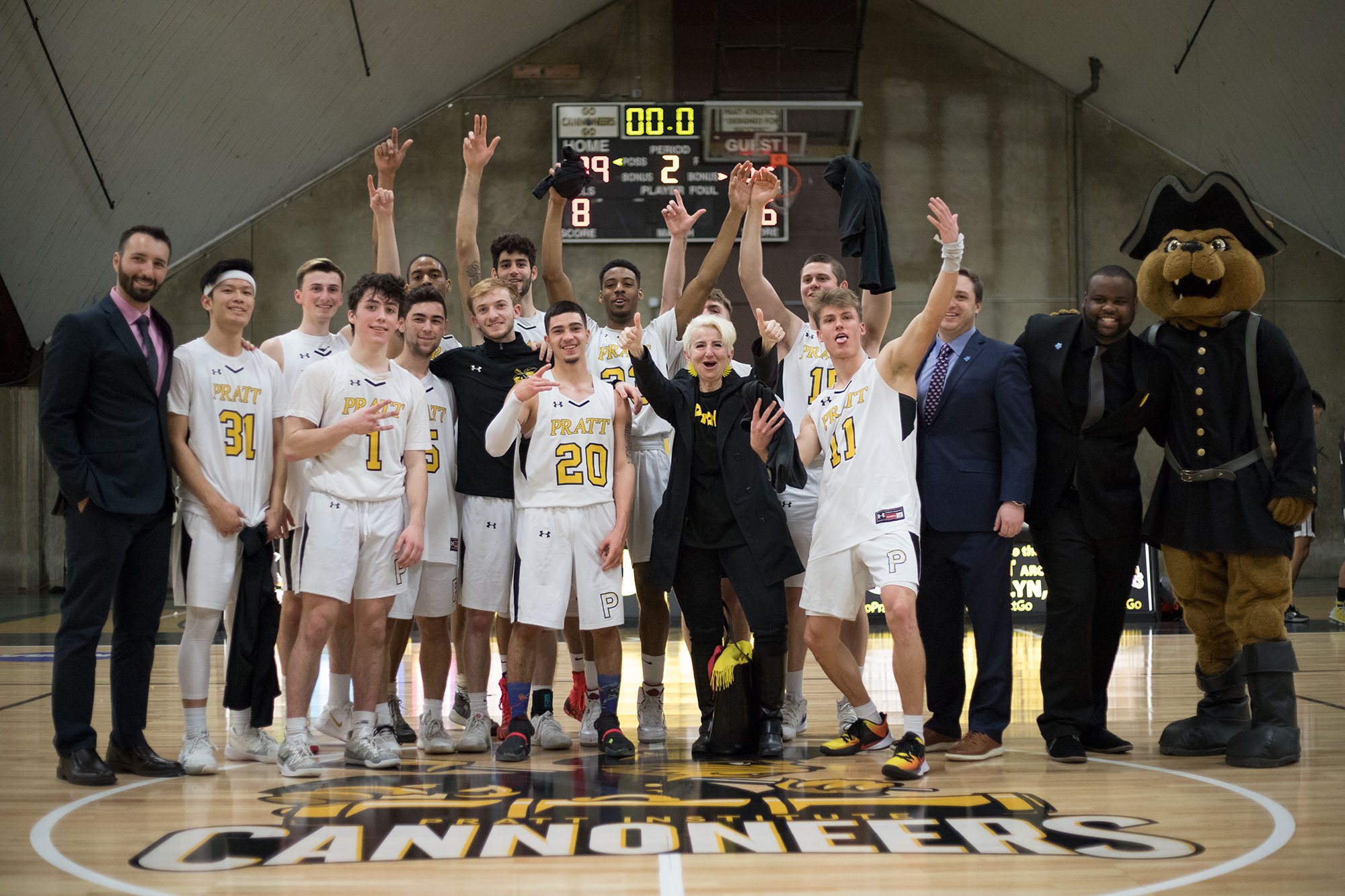 The Pratt Cannoneers, President Frances Bronet, and Pratt Athletics' mascot, Charlie post for a group photo in the ARC after the win against RISD