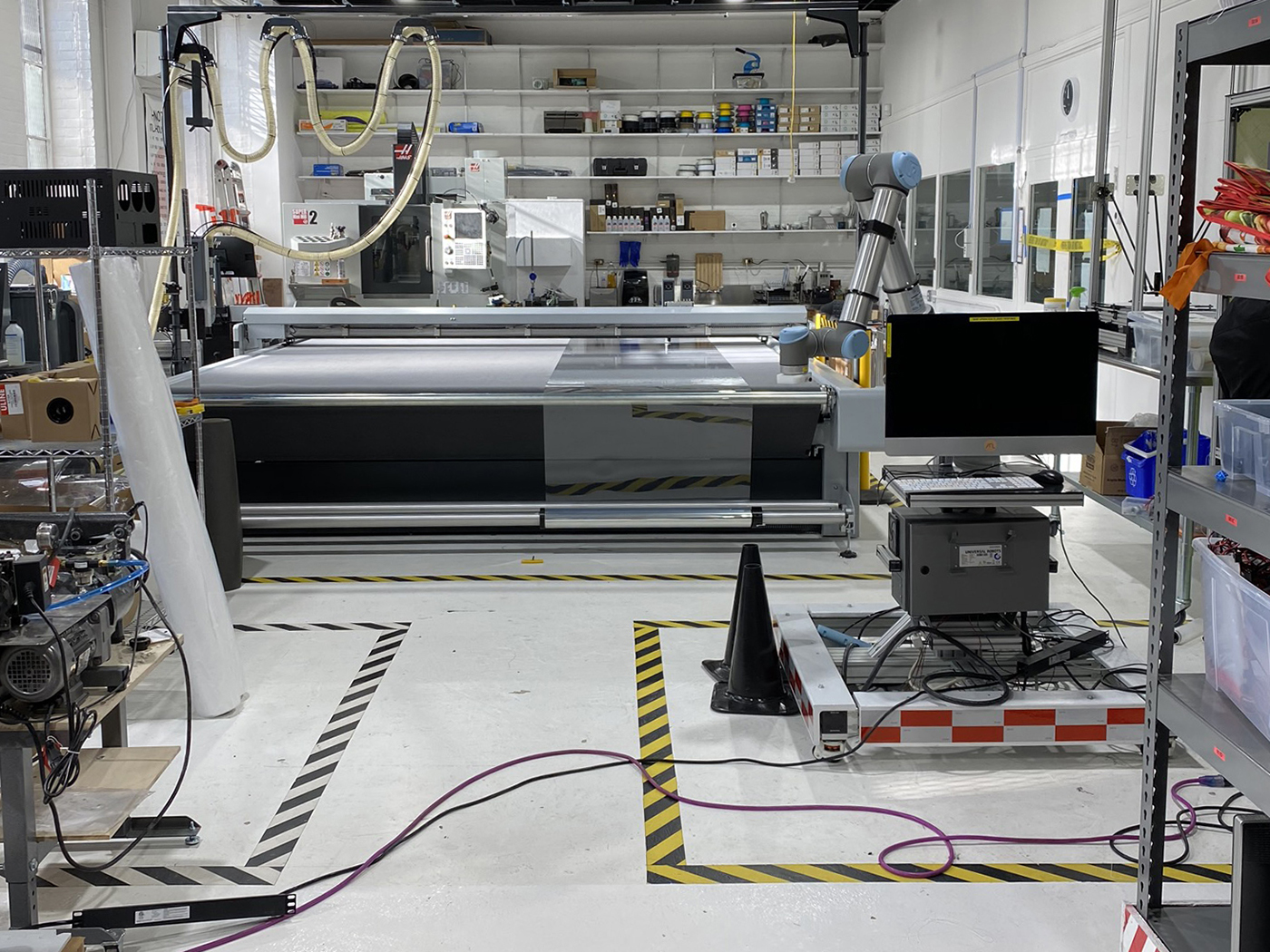Roll feed setup with the Zünd digital cutter for the non-stop automatization of cutting shields for attachment to a 3D-printed visor (photo by Scott Sorenson)